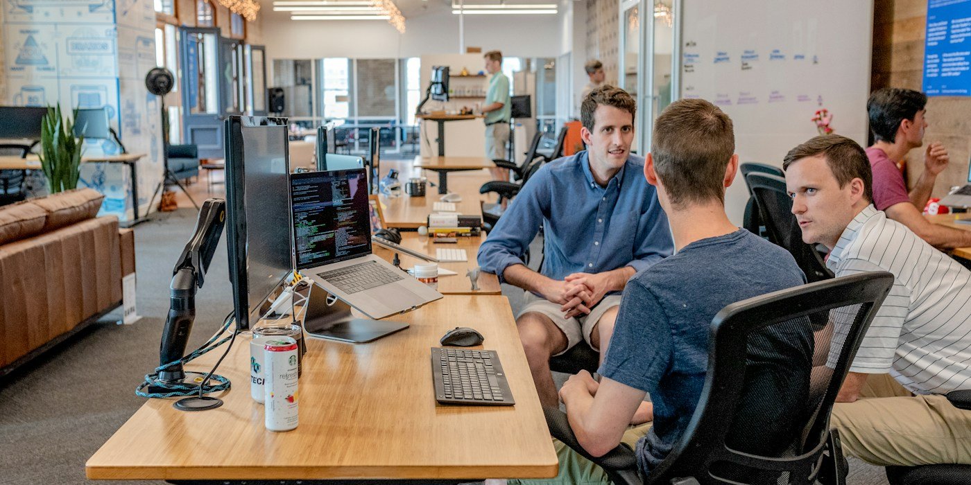 A team discussing software and digital work around a computer
